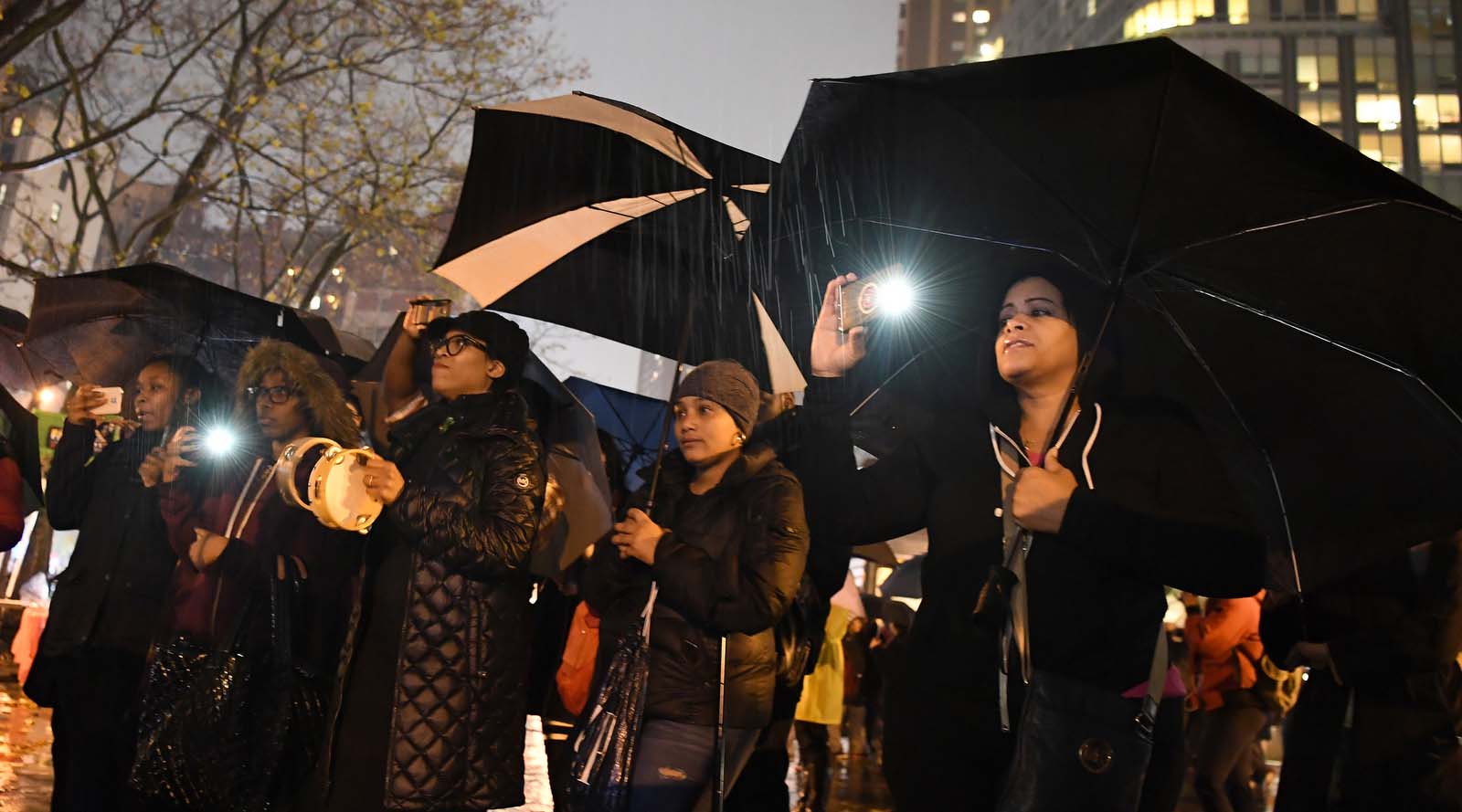 group taking pictures and holding umbrellas